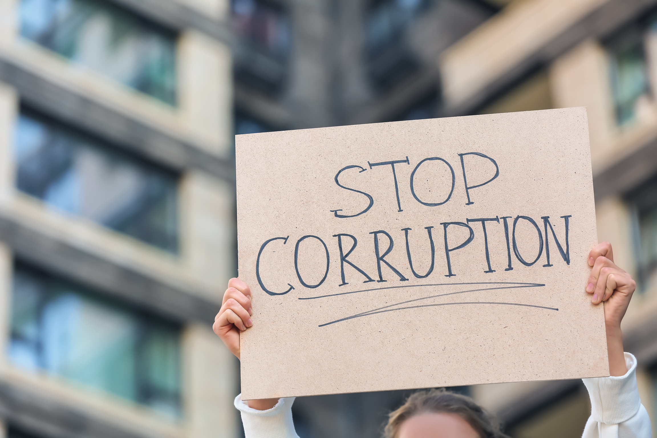 Woman Holding Placard with Text STOP CORRUPTION Outdoors